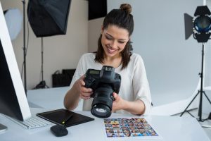 Female photographer reviewing captured photos in her digital camera ~ SilverState Web Design